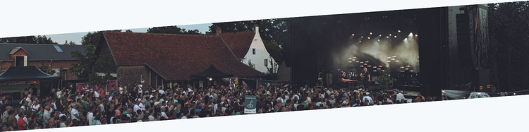 A crowd watches a band play at an outdoor festival